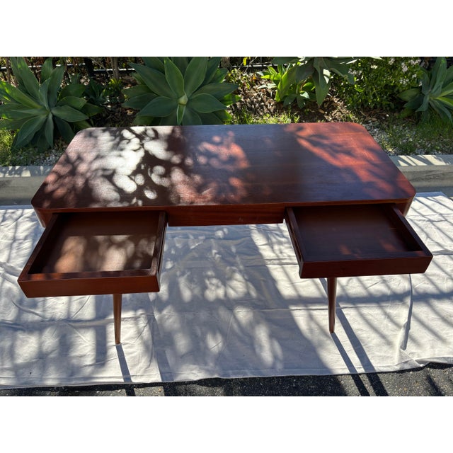 This charming mid century desk features hidden drawers and generous legroom. Created in the style of a mid-century modern...