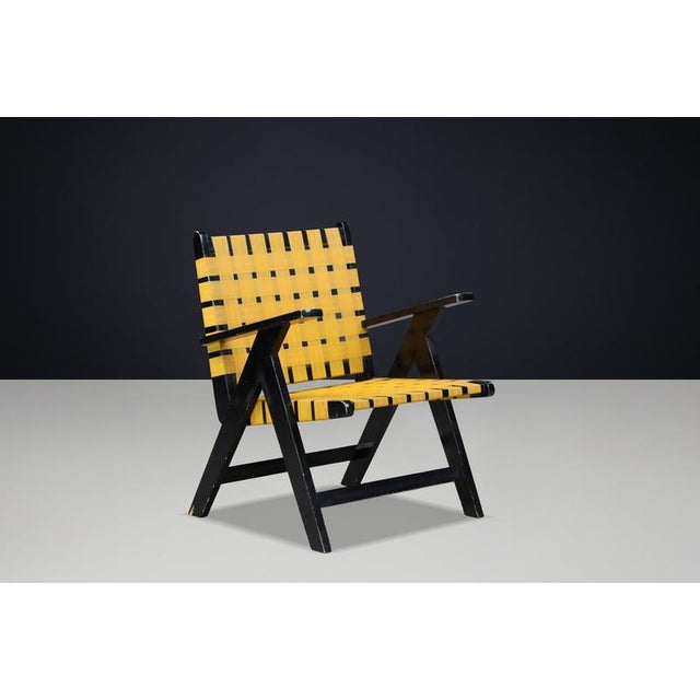 Mid-Century Modern Black Wood and Yellow Webbing Lounge Chair, Europe, 1950s A striking Mid-Century Modern lounge chair,...