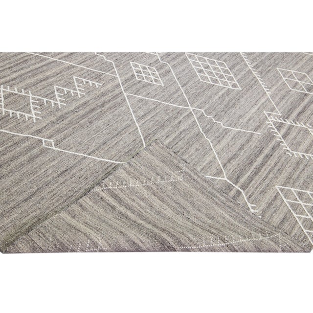Beautiful kilim handmade wool rug with a gray field. This custom modern flatweave rug part of our Nantucket collection has...