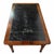 This antique writing table featuring an inset black leather writing surface framed in richly toned wood. The leather top...