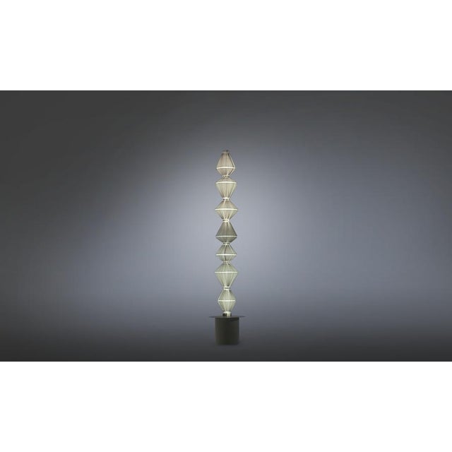 Oïphorique p gr floor lamp. Steel structure. Black lacquered canopy and black chrome trim disc. Light grey textil diffuser...