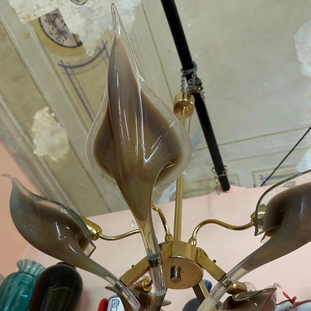 This chandelier is a striking example of Mid-Century Modern design with a touch of Hollywood Regency flair. It's glamorous...