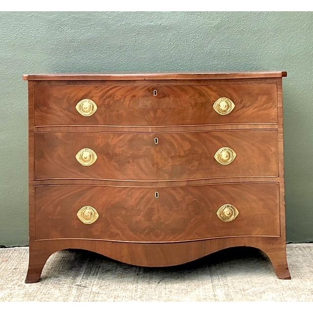 This masterfully crafted George III style commode features a dramatic serpentine front that epitomizes 18th-century...