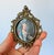 Vintage ornate Italian silk art picture in a brass-tone metal frame. The portrait is a miniature depiction of Marie...