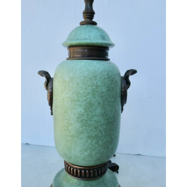 Mottles green glaze on the three-section urn with two bronze bands at the foot and lid were two coiled cobra mounts at the...