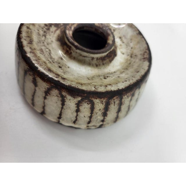 This signed stoneware vase boasts a distinctive design with rustic motifs and a brown and white glazed finish. Perfect for...