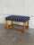 Featuring a cushioned rectangular top with brass nailhead trim, this ottoman rests on a turned wooden frame. Its...