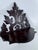 A striking small wall shelf featuring a dramatic pointed crest, pierced scrollwork, and richly carved foliage. The deep...