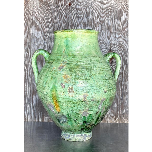 Add a touch of rustic charm to your space with this captivating vintage boho glazed ceramic urn. Featuring an enchanting...