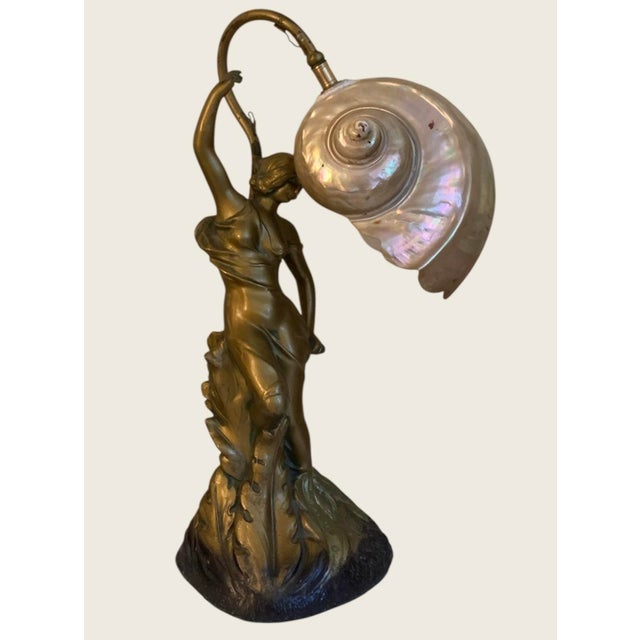 15” high, a spectacular and rare nautilus shell lamp, golden Art Nouveau lady with stem that comes up from the rear which...