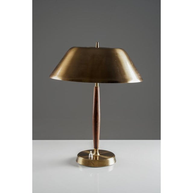 Elegant swedish mid-century table lamp by falkenbergs belysning. The lamp features a gently curved brass shade paired with...