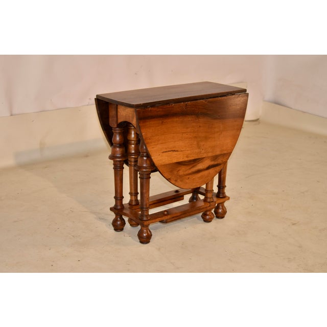 Period Edwardian walnut drop-leaf side table from England. The table has a richly grained top, following down to a simple...