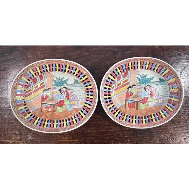 Pristine pair of mid-20th-century Chinese export porcelain reticulated oval plates. Beautifully hand-painted in a vibrant...