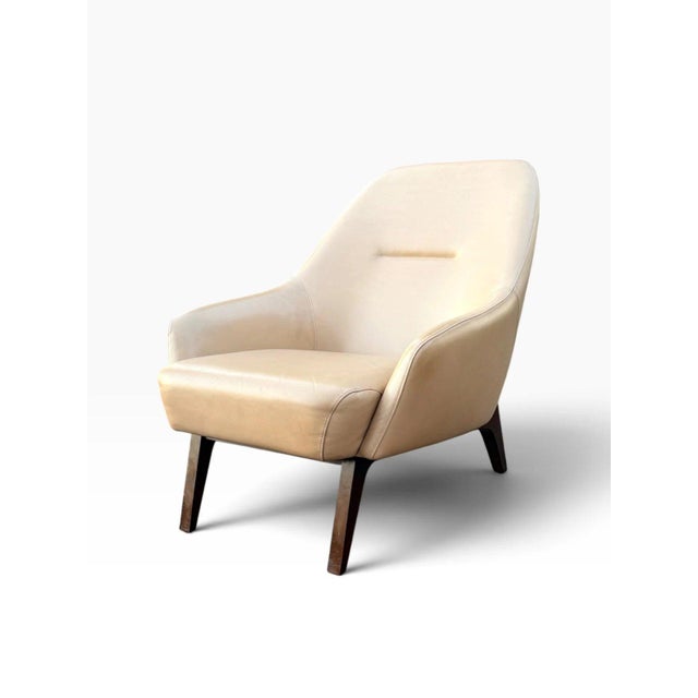 OVERVIEW A pair of leather lounge chairs designed by Adam Court, with a soft, enveloping shell and a very comfortable deep...