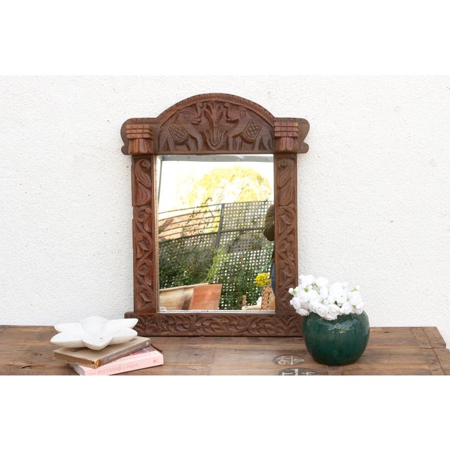 A mirror that acts as a talisman. This striking wall mirror is framed by a heavy, architectural surround inspired by the...