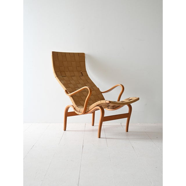 Iconic 'Pernilla' armchair by Bruno Mathsson, with curved wooden structure and woven seat, complete with matching...