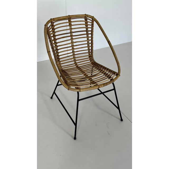 Woven rattan lounge chair, Italian design. Fits perfectly into a minimalist 1960s lounge setting. Matte black metal base.