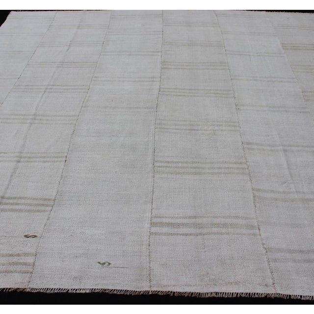Square vintage paneled flat-weave Kilim from Turkey in white and neutral tones This multi paneled Kilim is an example of...