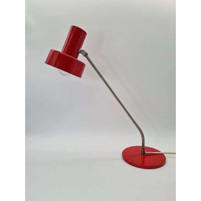 A minimalist desk lamp from the 1970s, manufactured by Elma. The design, characteristic of the era, combines lacquered...