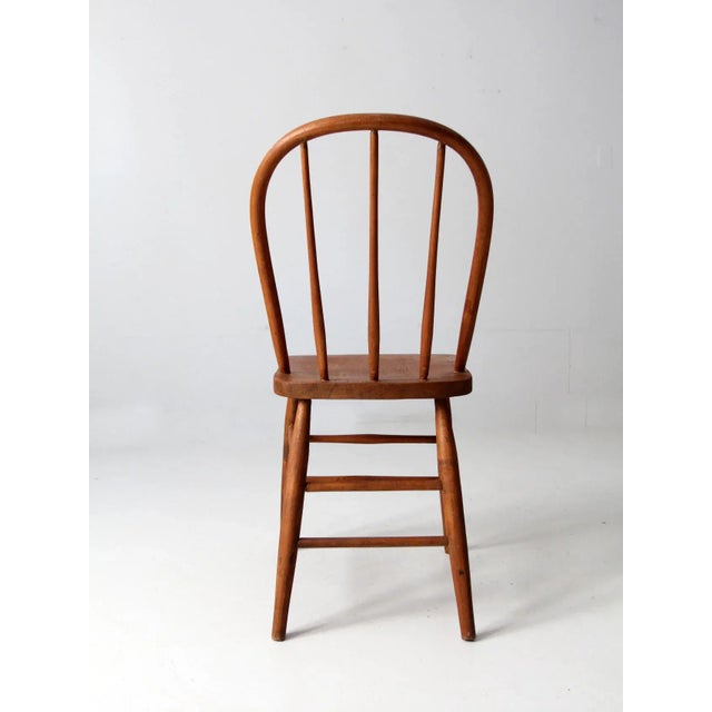 This is an antique bow back Winsdor chair. The classic farmhouse dining chair has a round spindle back. Beautiful patina...
