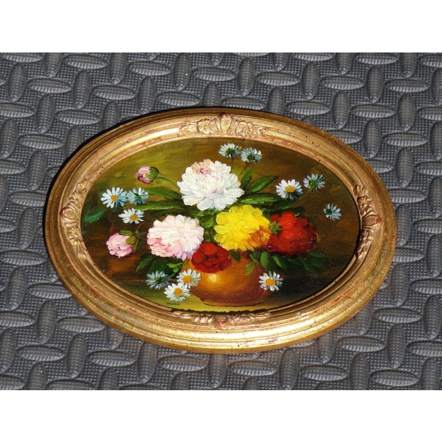 Pair of vintage original hand-painted still life oil paintings depicting bouquets of flowers in vases, set within ornate...