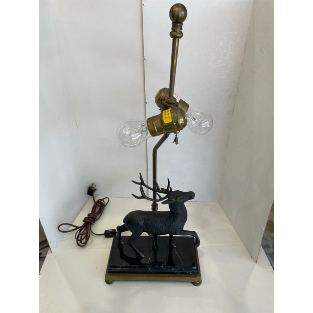 The Vintage CHAPMAN Bronze Elk Stag Sculpture Table Lamp features a rustic brown color and a unique design with a marble...