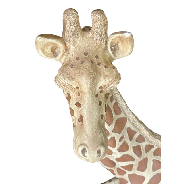 Add a touch of whimsical charm and safari-inspired style to your space with this vintage seated giraffe sculpture by...
