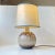 Spherical ceramic table light decorated with earthy drip glazes. The light features a partially perforated corpus and...