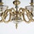 A gilt bronze chandelier offers faceted central font with eight scrolled foliate form arms terminating in candle lights,...