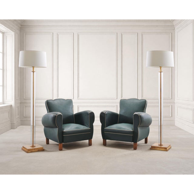 A stylish and charming pair of 20th century French Art Deco club chairs, upholstered in a deep green leatherette naugahyde...