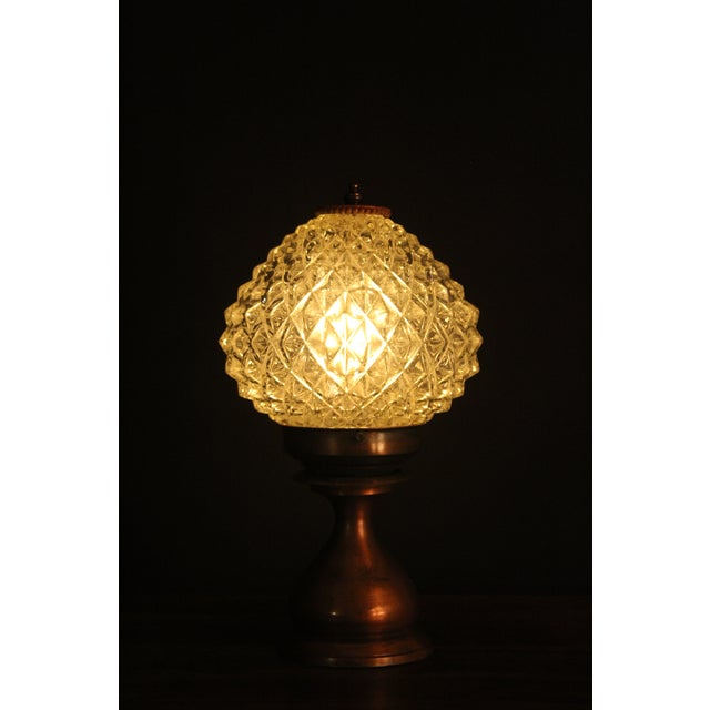 Petite country French table lamp. Spun copper base. Pressed crystal shade. Sculptural shape. The crystal shade emits...