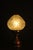 Petite country French table lamp. Spun copper base. Pressed crystal shade. Sculptural shape. The crystal shade emits...