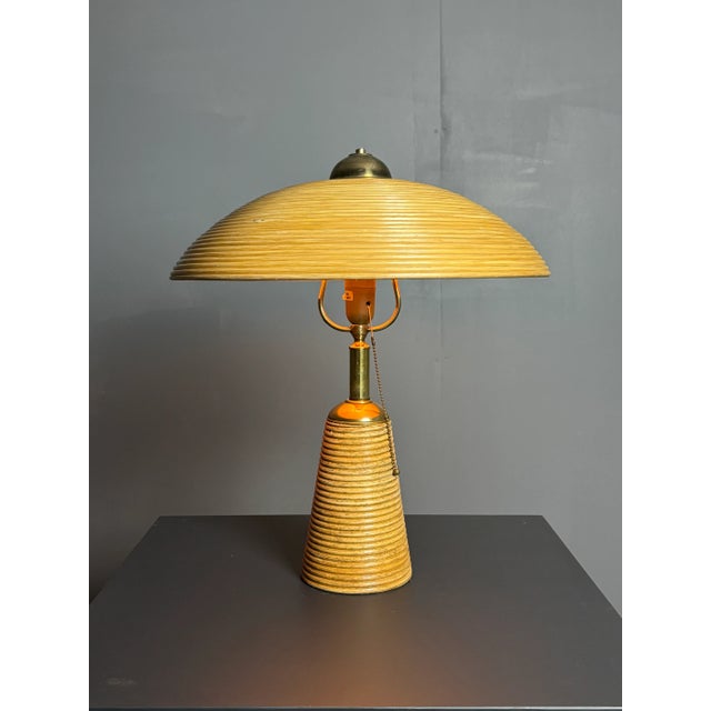 Gorgeously proportioned pencil reed rattan table lamp with brass. This lamp is in good vintage condition with patinated...