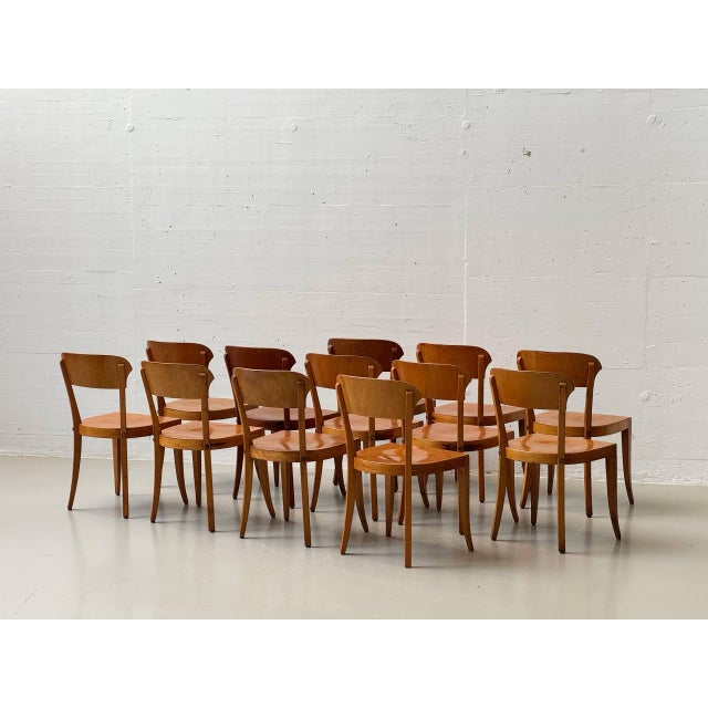 The chair features a gently curved, ergonomically shaped backrest made of molded plywood and a solid, organically rounded...