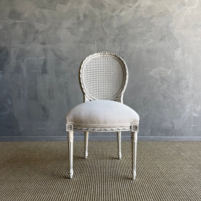 20”w x 21”d x 38”h SH: 20” SD: 17” Antique French Louis XVI Style Cane chair painted in a french oyster white finish with...