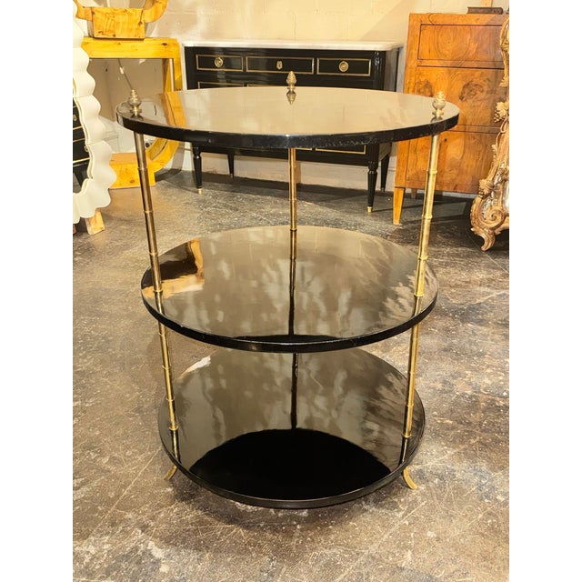 The Italian Brass Bamboo and Black Lacquered Etagere Table is a stylish and modern piece of furniture perfect for any...