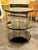 The Italian Brass Bamboo and Black Lacquered Etagere Table is a stylish and modern piece of furniture perfect for any...