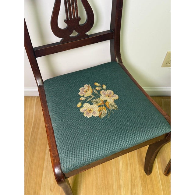 Set of four vintage, drop-in seat side chairs featuring graceful lyre-form splats, shaped crest rails, and tapered legs....