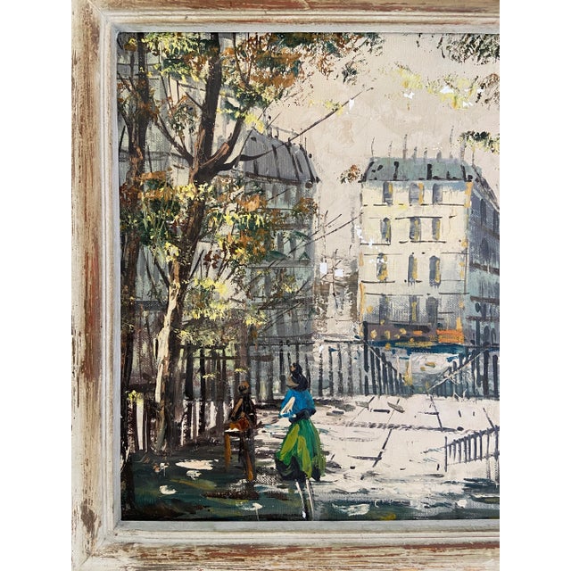 A vintage oil on canvas painting, most likely from the 1940's or 1950's, depicting a Parisian street scene in an...