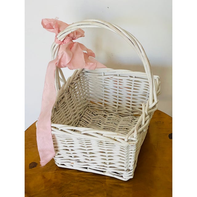 Cute lovely wicker basket painted white and decorated with a silk pink bow.