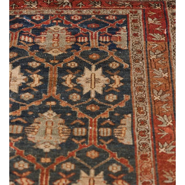 This traditional hand-woven Persian Malayer rug has a dark navy field with overall design of stepped lozenge lattice...