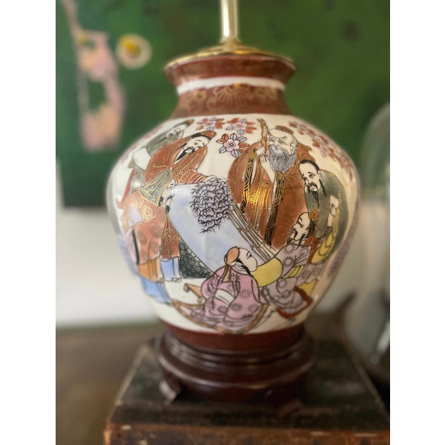 Gorgeous Asian lamp, presented in an oxblood red against a white, porcelain ceramic, depictions of courtlife, traditional...