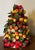 Table top Christmas tree profusely decorated with millinery fruit circa 1950's. there are berries, oranges and lemons with...