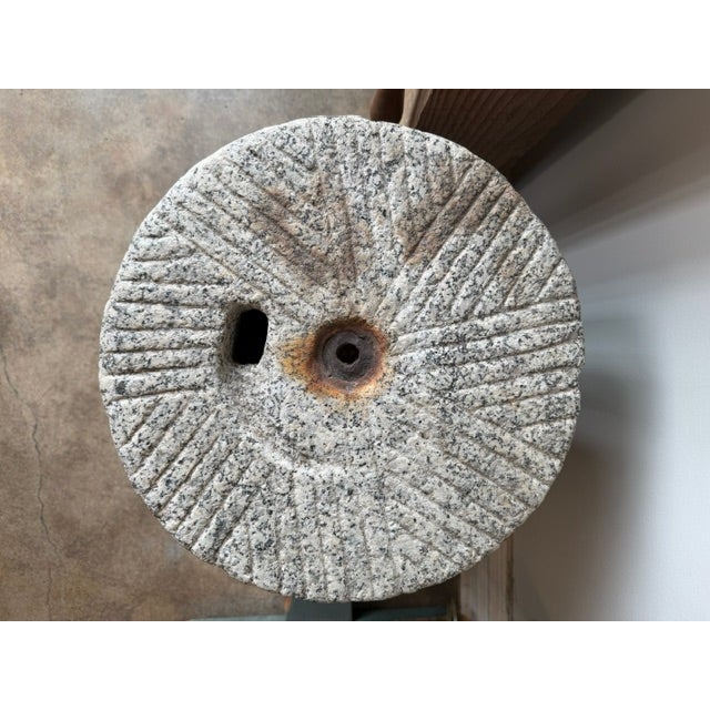 Beautiful side table or drink table with an antique millstone top and a round bronze base. Millstones were used to grind...