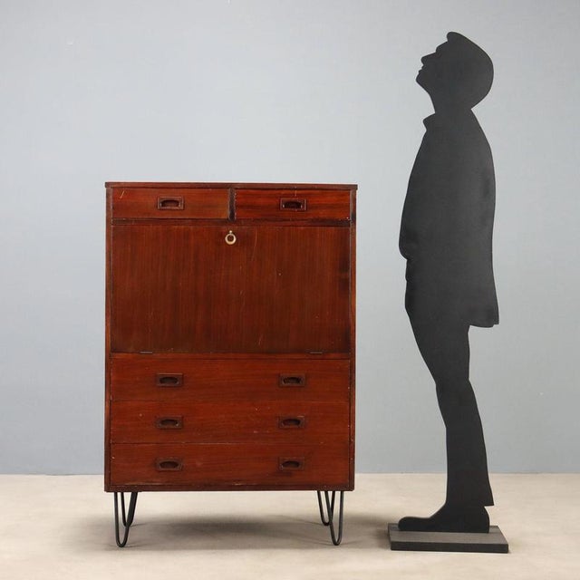 1960s vintage sideboard made of stained mahogany veneer, featuring a functional and linear design. Equipped with a drop-...