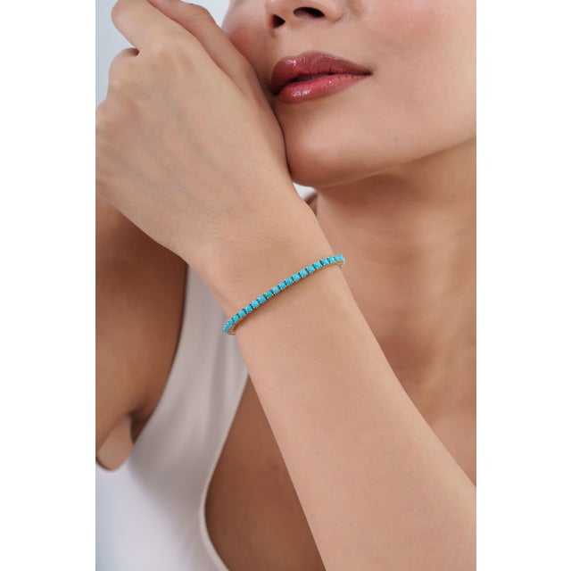 This statement tennis bracelet showcases 7.98 carats of natural round cabochon turquoise, set in rich 14k yellow gold....