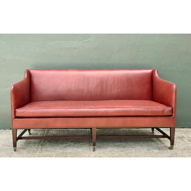 This settee-style sofa presents a tailored, architectural silhouette rooted in classic English design tradition, its high,...