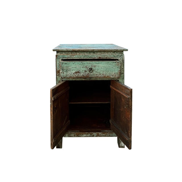 This charming antique look cabinet radiates a rustic, weathered allure, its faded green exterior showcasing a beautifully...