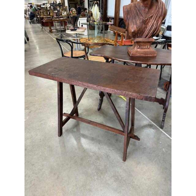 Italian wood console from a wine shop in Florence. Thick rough cut wood top and a stretcher base. 41”w x 19”d x 31”h 44-087