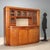Early 20th-century mahogany sideboard featuring a raised section with five beveled glass doors, adorned with elegant brass...